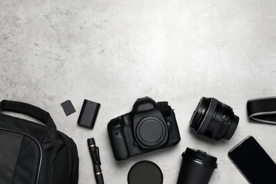 Photo of Professional photography equipment and backpack on grey stone table, flat lay. Space for text