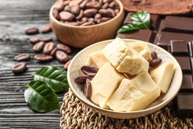 Photo of Organic cocoa butter on black wooden table, closeup