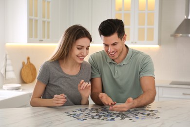 Happy couple playing with puzzles at home