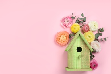 Photo of Stylish bird house and fresh flowers on pink background, flat lay. Space for text