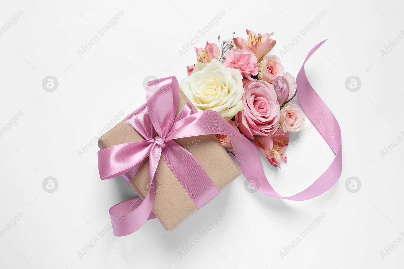 Photo of Gift box and beautiful flowers on white background, flat lay