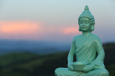 Decorative Buddha statue in mountains. Space for text