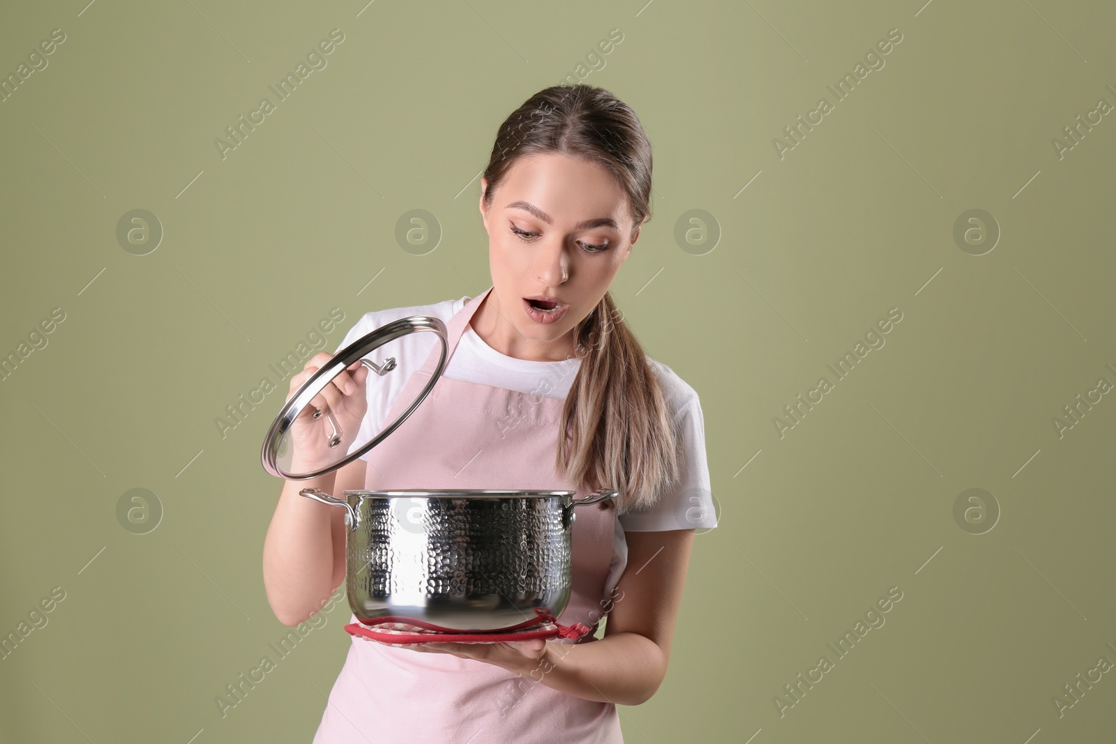 Photo of Surprised woman with pot on olive background