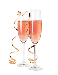 Glasses of rose champagne with gold streamer isolated on white
