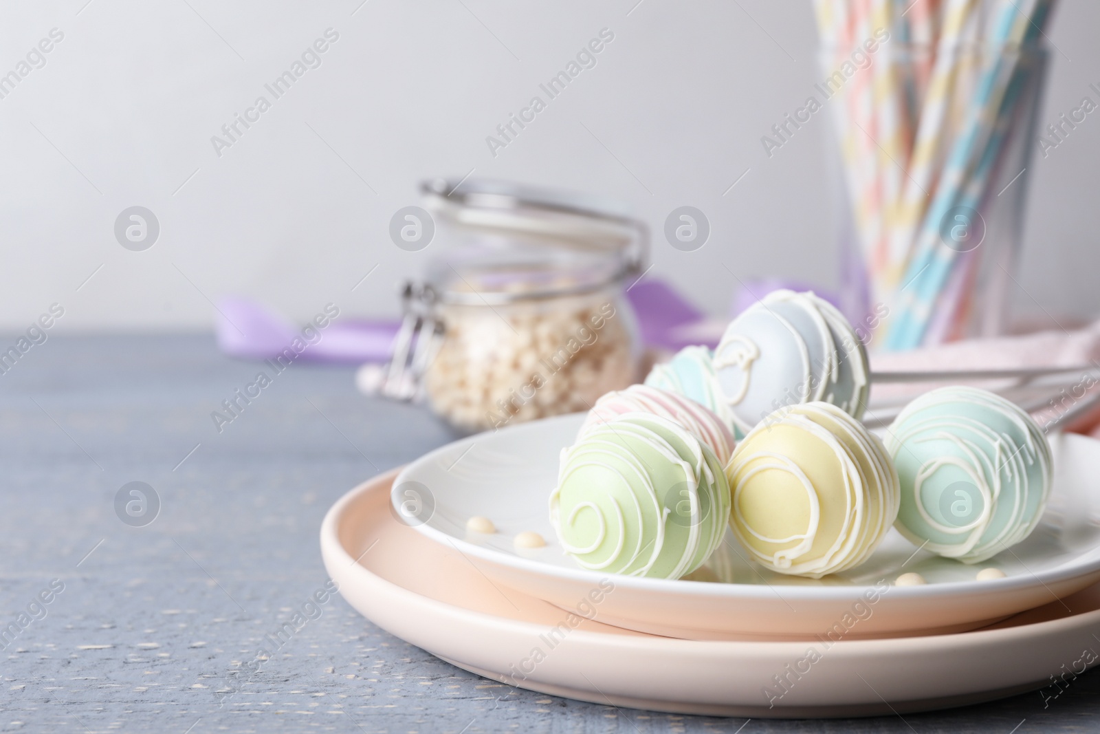 Photo of Sweet cake pops on grey wooden table. Space for text