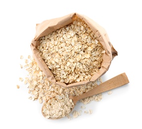 Photo of Paper bag and spoon with raw oatmeal on white background. Healthy grains and cereals