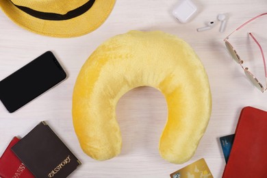 Photo of Flat lay composition with yellow travel pillow and smartphone on white wooden background