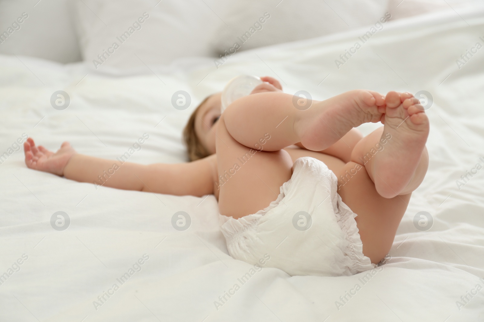 Photo of Cute little baby in diaper on bed