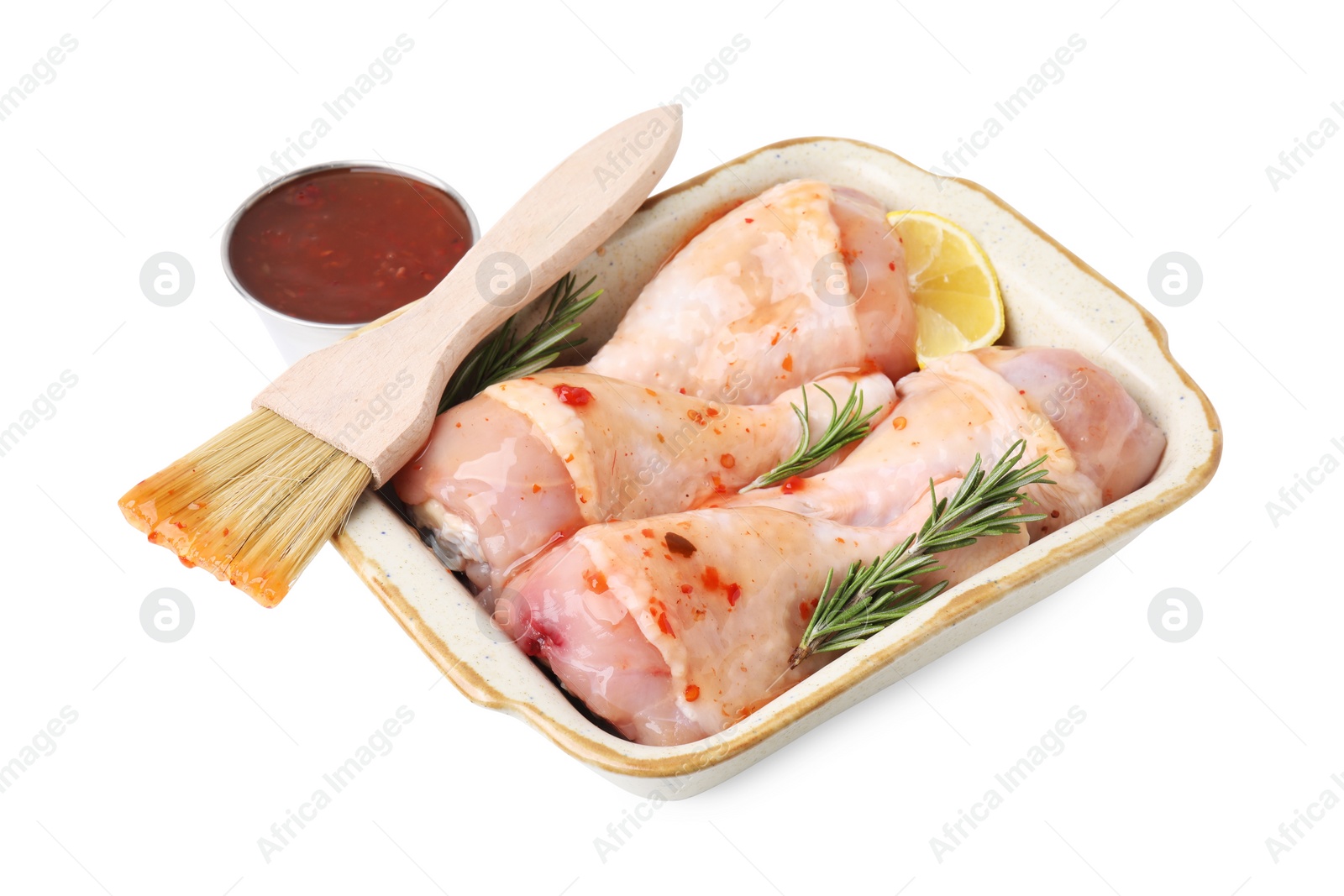 Photo of Fresh marinade, basting brush, raw chicken drumsticks, rosemary and lemon isolated on white