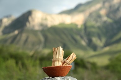 Many palo santo sticks on stone surface in high mountains