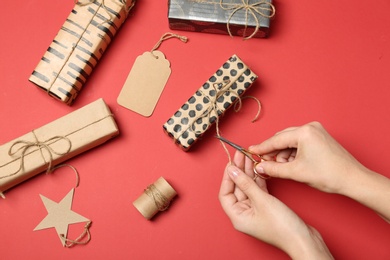 Photo of Woman decorating gift box on color background, top view