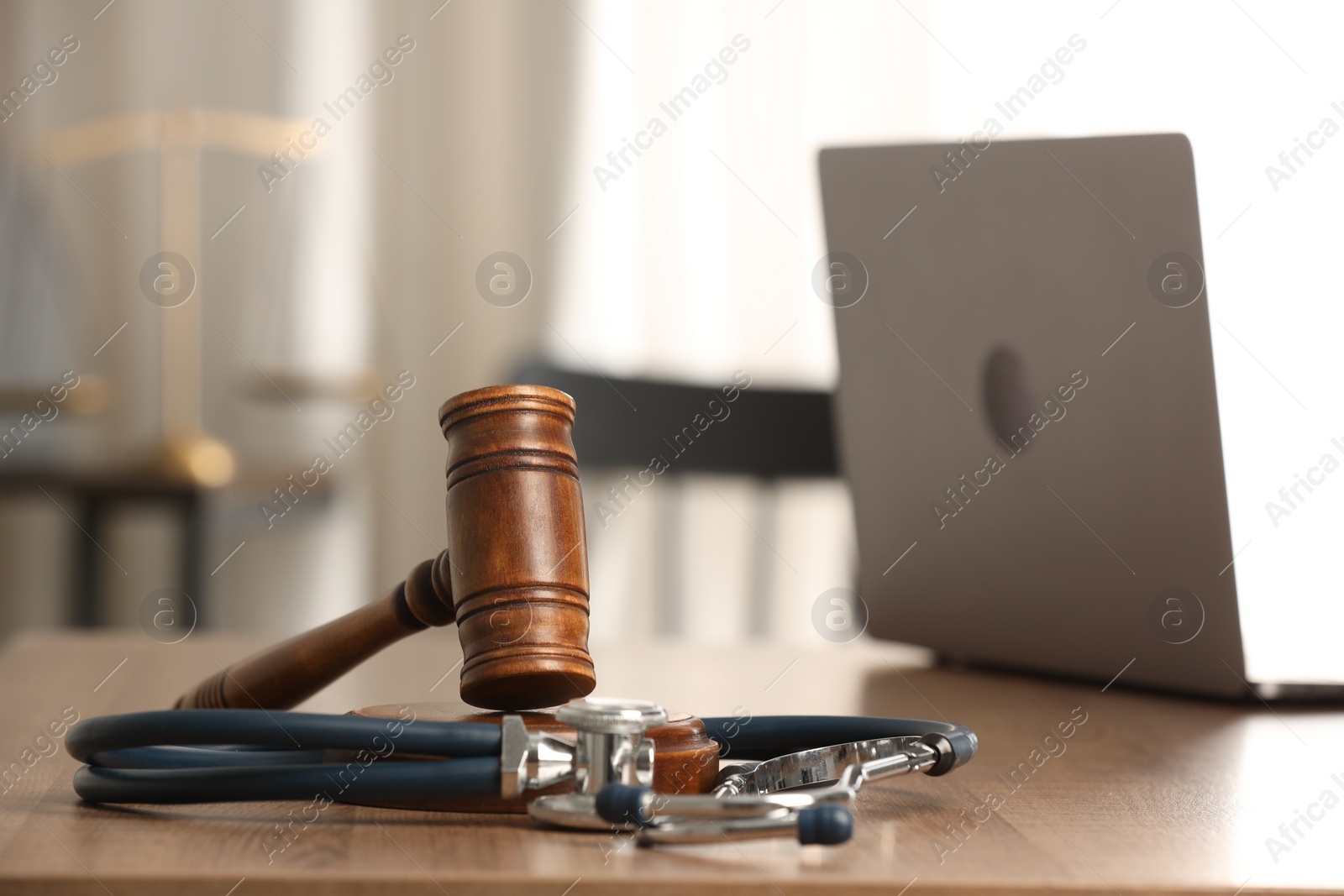 Photo of Law concept. Gavel, laptop and stethoscope on wooden table