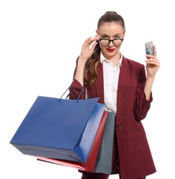 Stylish young businesswoman with shopping bags and credit card on white background