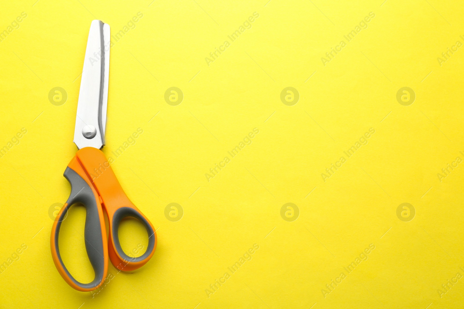 Photo of Pair of sharp scissors on color background, top view. Space for text