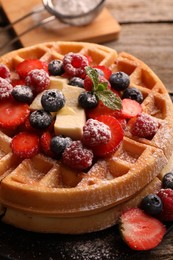 Photo of Tasty Belgian waffles with fresh berries, cheese and powdered sugar on table, closeup