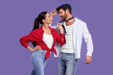 Photo of Beautiful couple dancing together on violet background