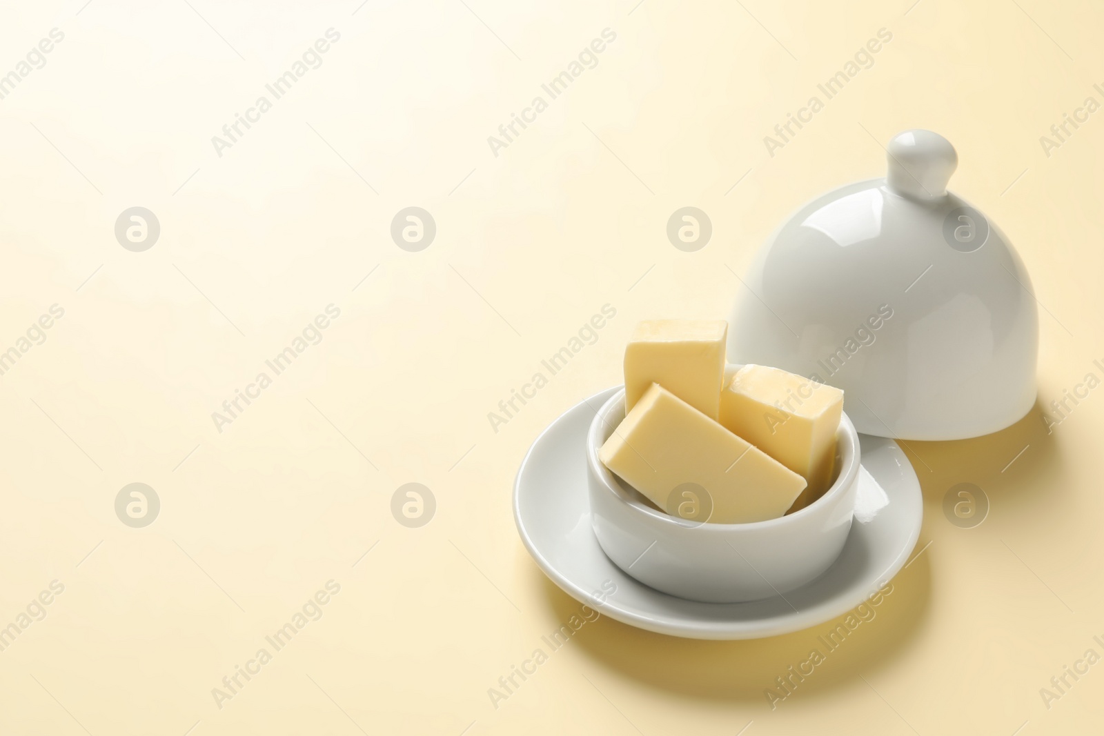 Photo of Dish with fresh butter on color background. Space for text