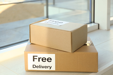 Photo of Parcels with sticker Free Delivery on window sill. Courier service