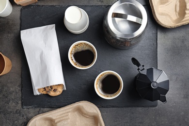 Composition with aromatic hot coffee in paper cups and cookies on table