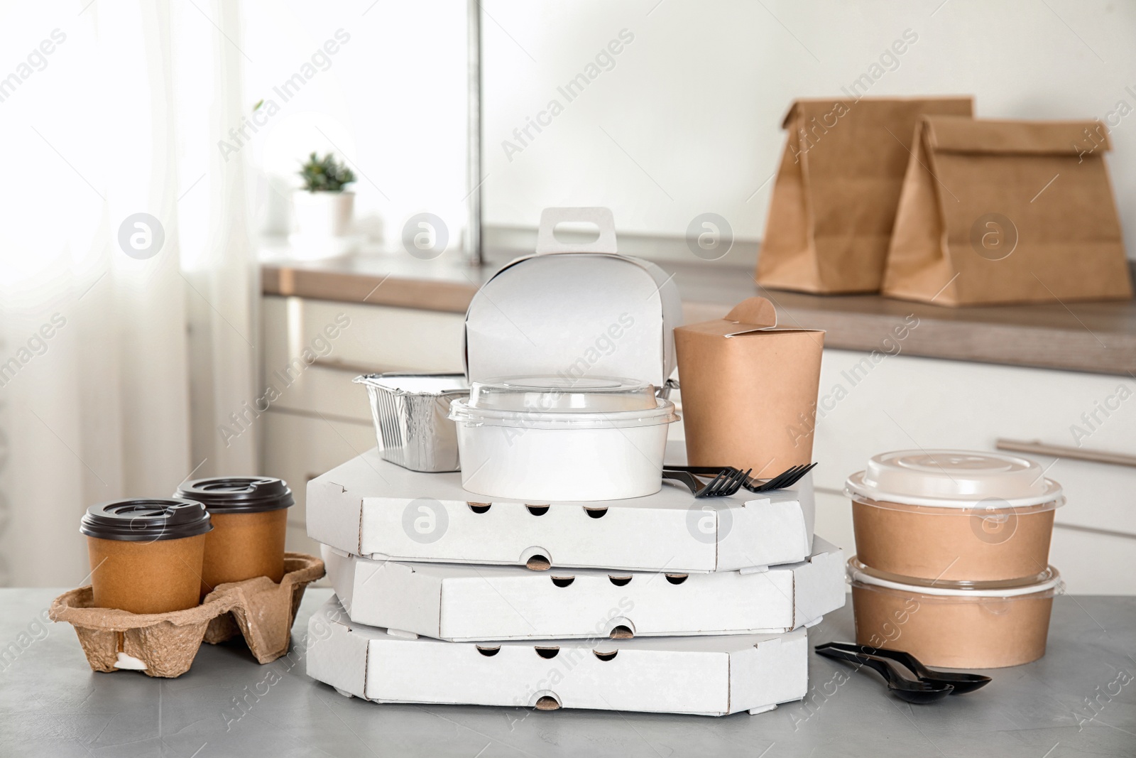 Photo of Various takeout containers on table in kitchen. Food delivery service