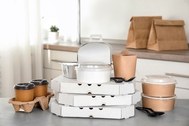 Photo of Various takeout containers on table in kitchen. Food delivery service
