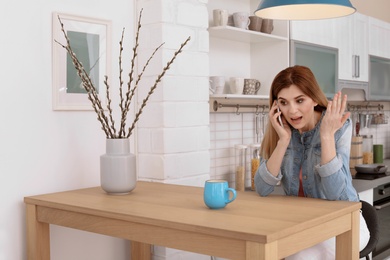 Woman arguing on mobile phone at home