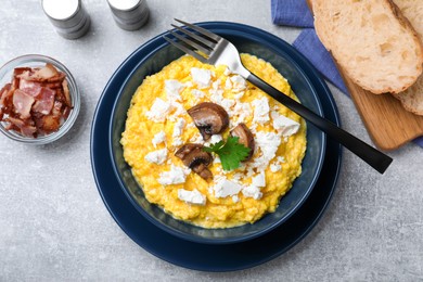 Tasty banosh served with brynza and mushrooms on grey table, flat lay. Traditional Ukrainian dish