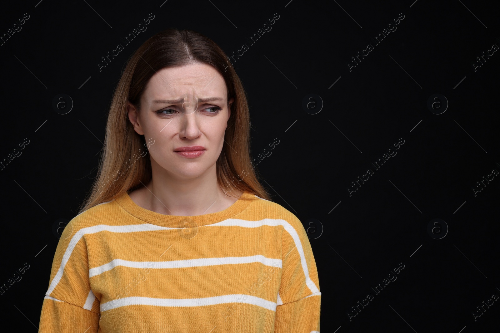 Photo of Portrait of sad woman on black background, space for text