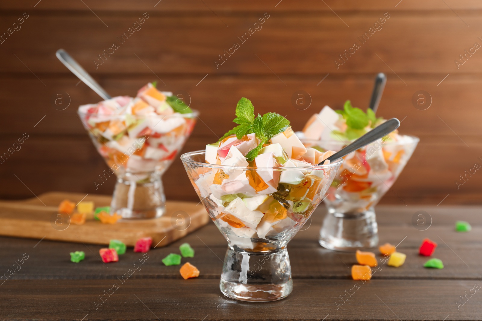 Photo of Delicious broken glass jelly dessert on wooden table