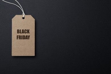 Photo of Tag with words Black Friday on dark background, top view. Space for text
