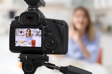 Photo of Food blogger recording video in kitchen, focus on camera display. Space for text