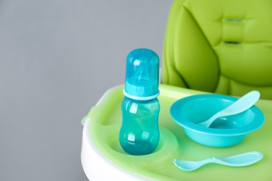 Photo of Set of plastic dishware on white feeding table. Serving baby food