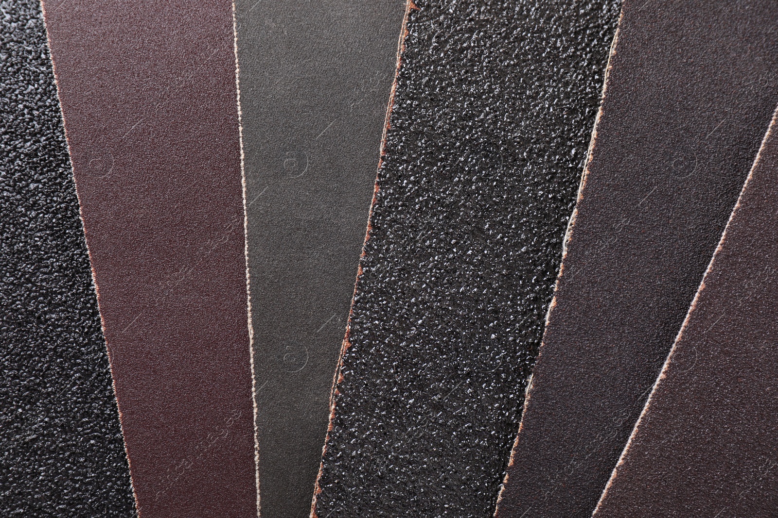 Photo of Many sheets of sandpaper as background, top view