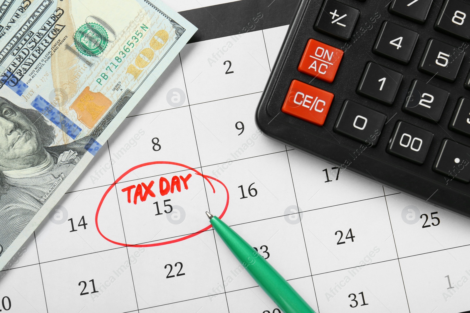 Photo of Calendar with date reminder about tax day, pen, money and calculator, top view