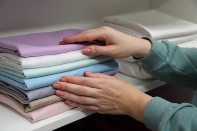 Photo of Customer choosing bed linens in shop, closeup