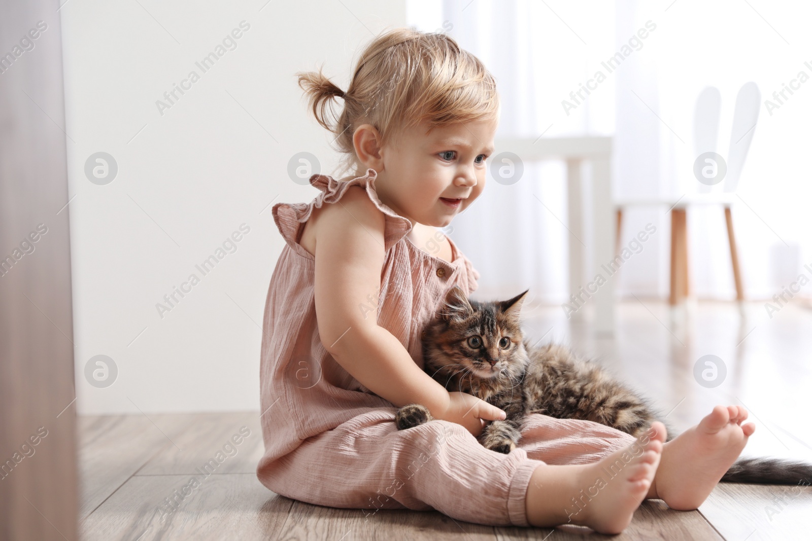 Photo of Cute little child with adorable pet on floor at home