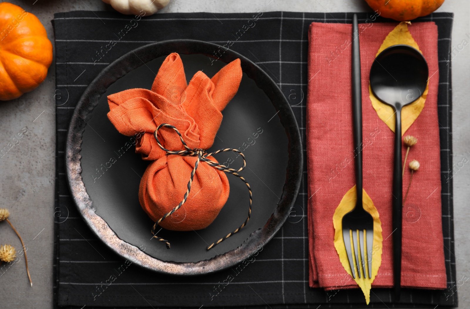 Photo of Seasonal table setting with pumpkins and autumn leaves on grey background, flat lay