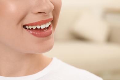 Photo of Woman with healthy teeth on blurred background, closeup. Space for text
