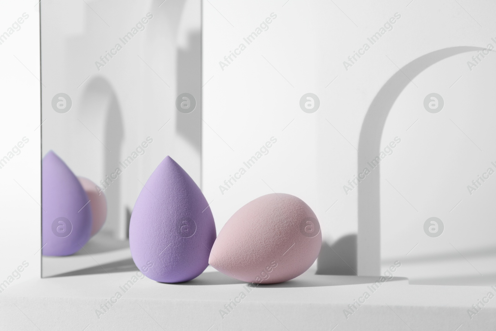 Photo of Stylish presentation of makeup sponges on white background