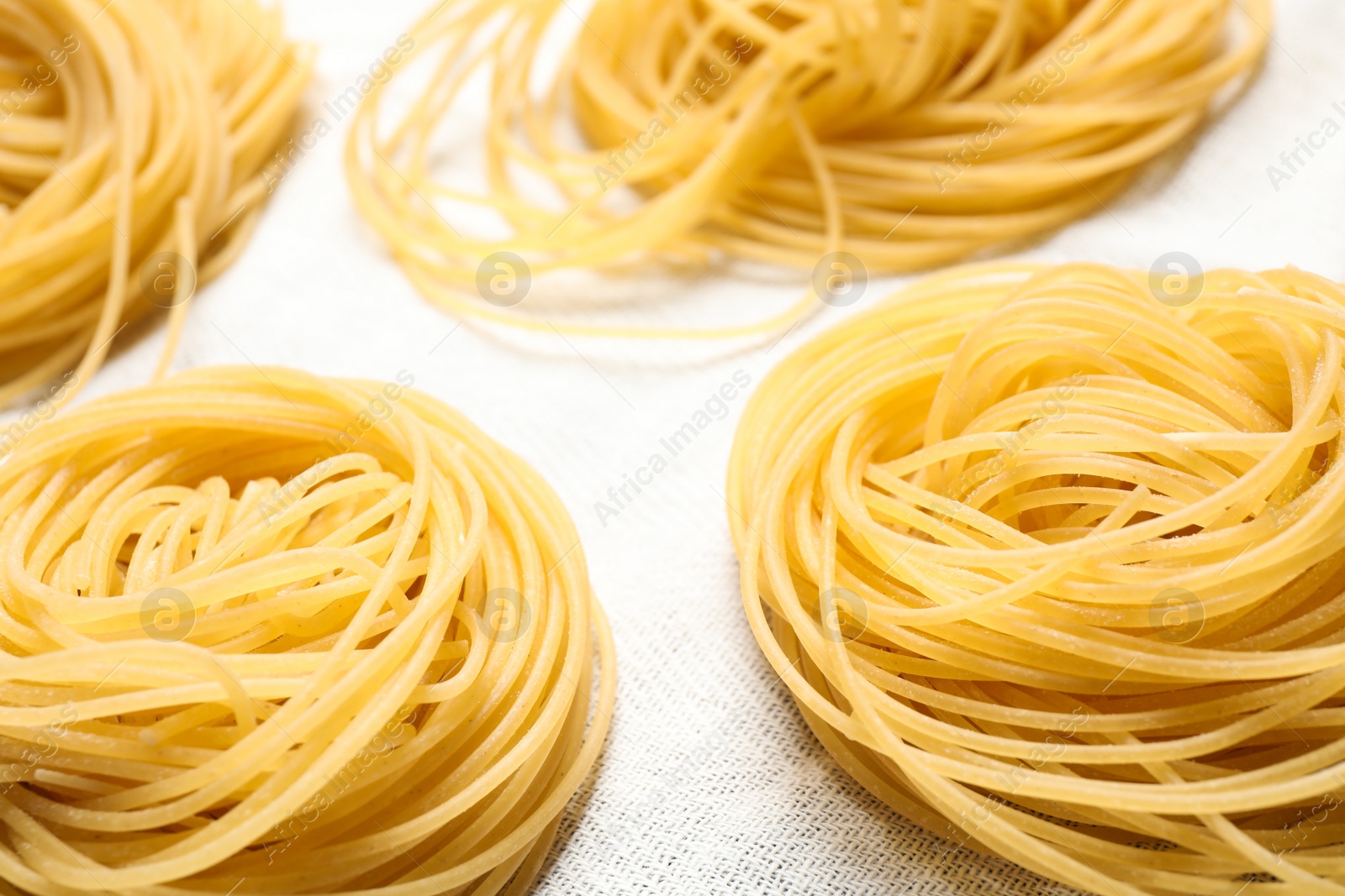 Photo of Capellini pasta on white tablecloth, closeup view