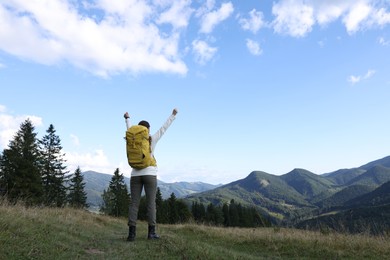 Photo of Triumphant tourist on top of mountain, back view. Space for text