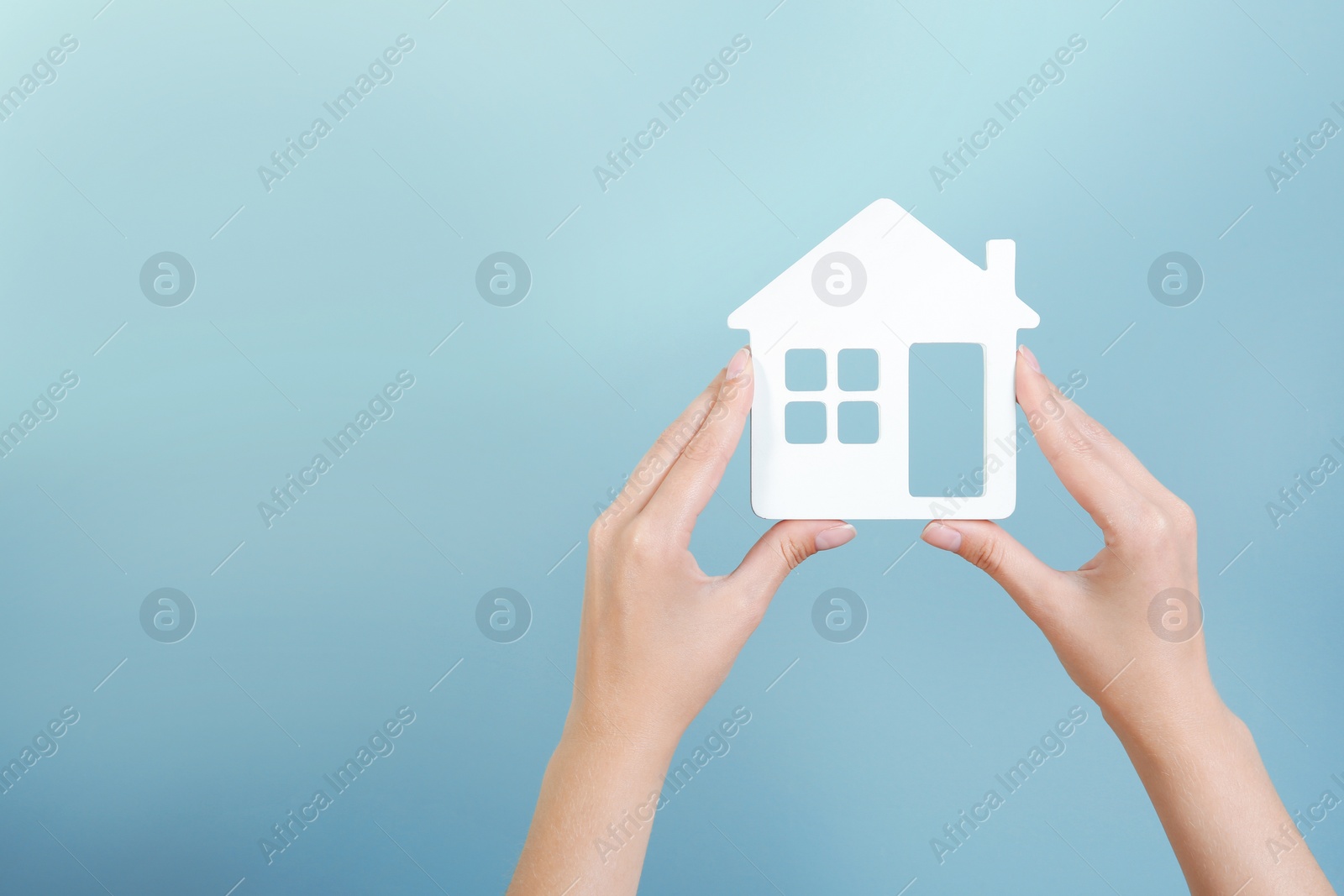 Photo of Woman holding house model on color background