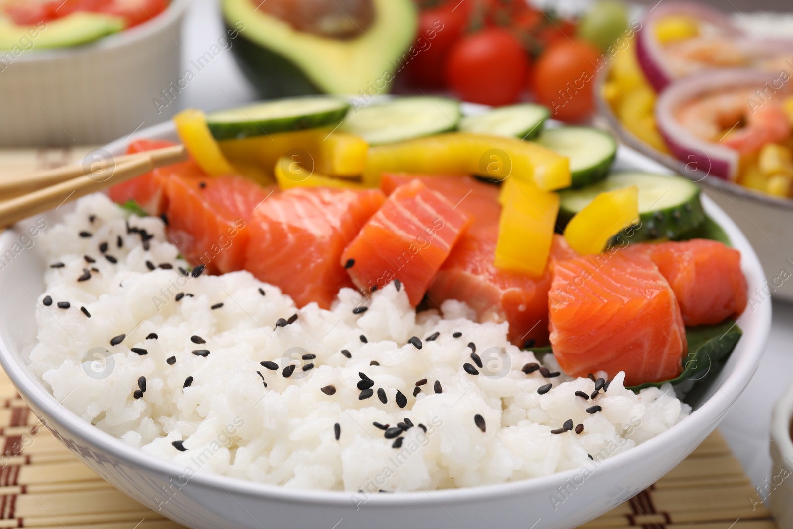 Photo of Delicious poke bowl with salmon, rice and vegetables on table, closeup