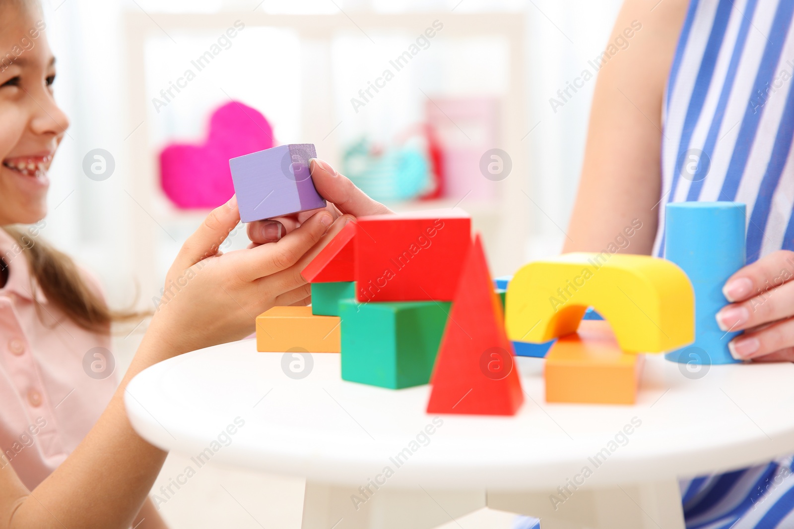 Photo of Woman and her child playing with colorful blocks at home, closeup