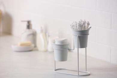 Cotton buds and pads on white table in bathroom, space for text