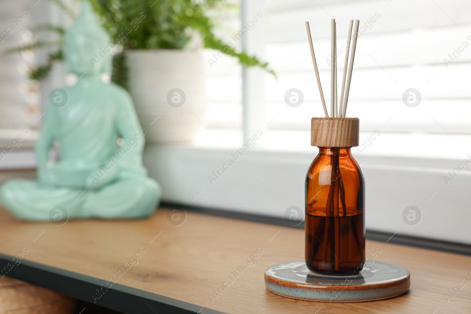 Photo of Air reed freshener on wooden table near window, space for text