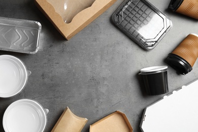 Photo of Frame of different takeout containers and space for text on grey background, flat lay. Food delivery service