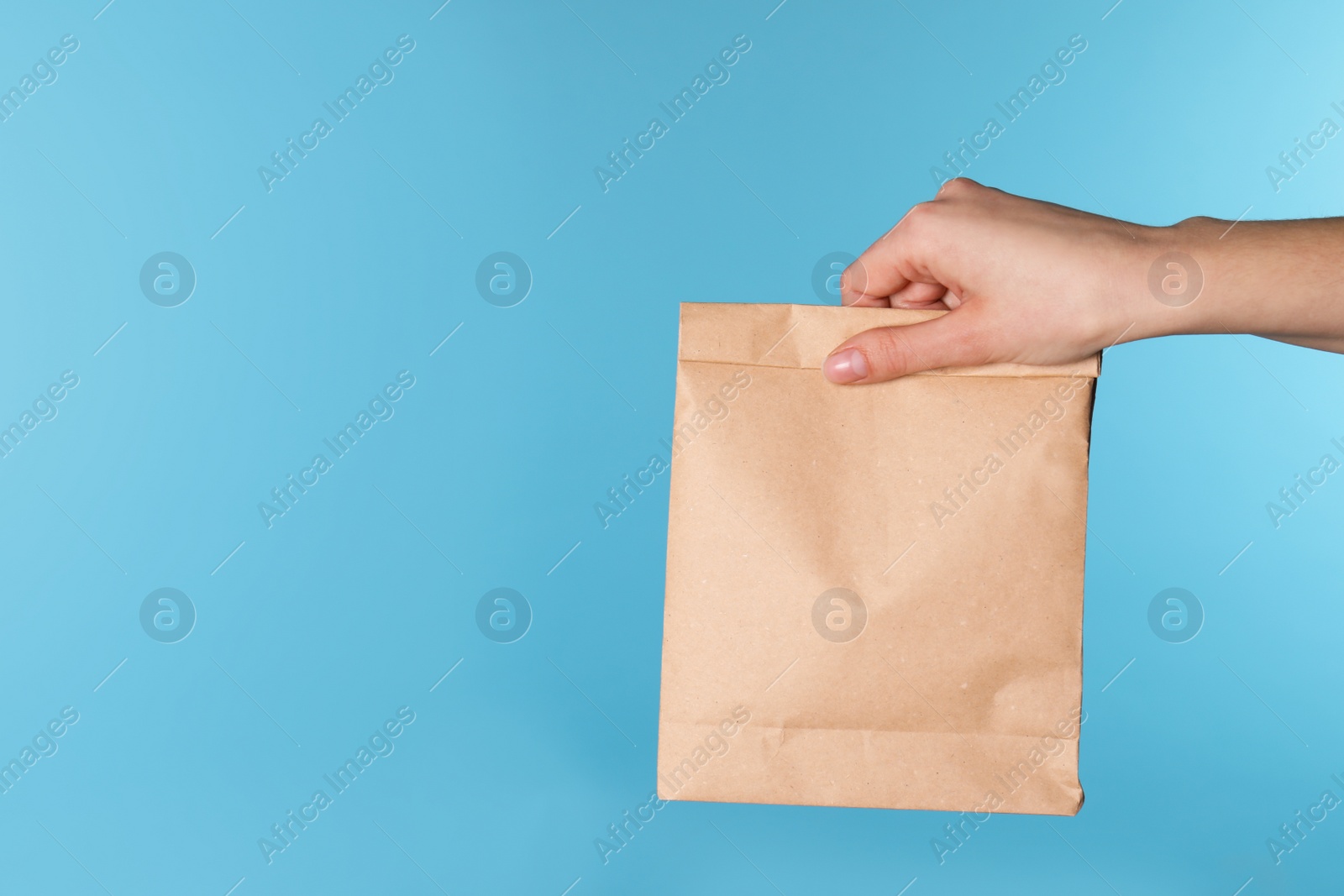 Photo of Woman holding paper bag on color background. Mockup for design