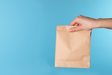 Woman holding paper bag on color background. Mockup for design