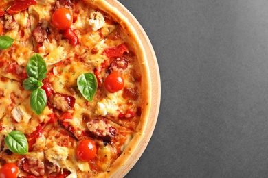 Delicious pizza with tomatoes and sausages on table, top view